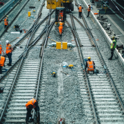 a group of men standing on top of train tracks