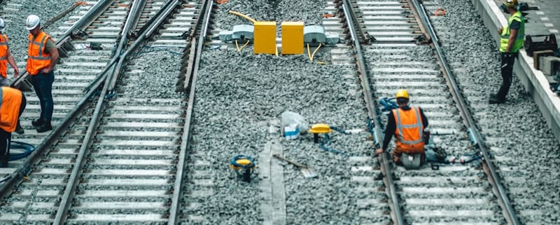 a group of men standing on top of train tracks