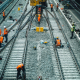 a group of men standing on top of train tracks