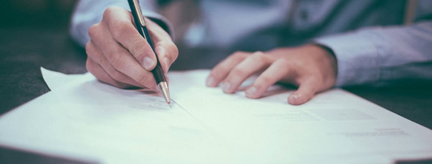 man writing on paper