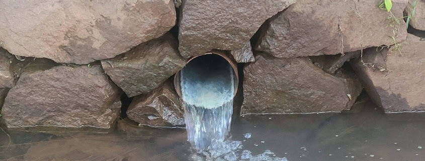 a large pipe is coming out of the water