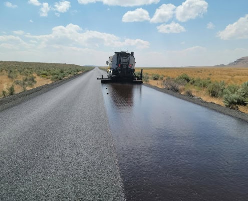 a large truck driving down a wet road